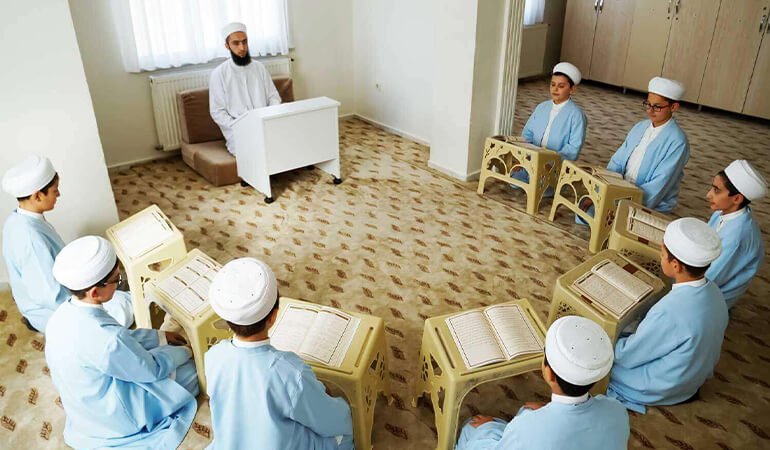 Hilal şeklinde oturmuş talebelerle medrese sınıf ortamı