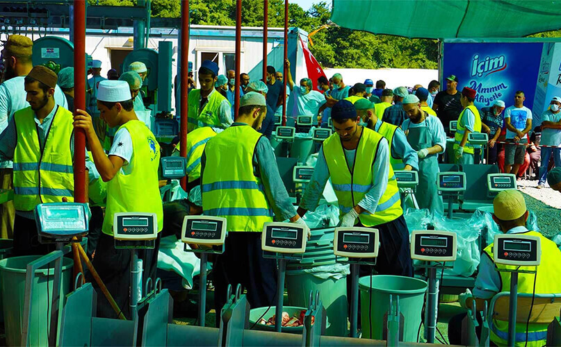 Otomatik makinelerle hızlı kesim ve tartım yapan çalışanlar